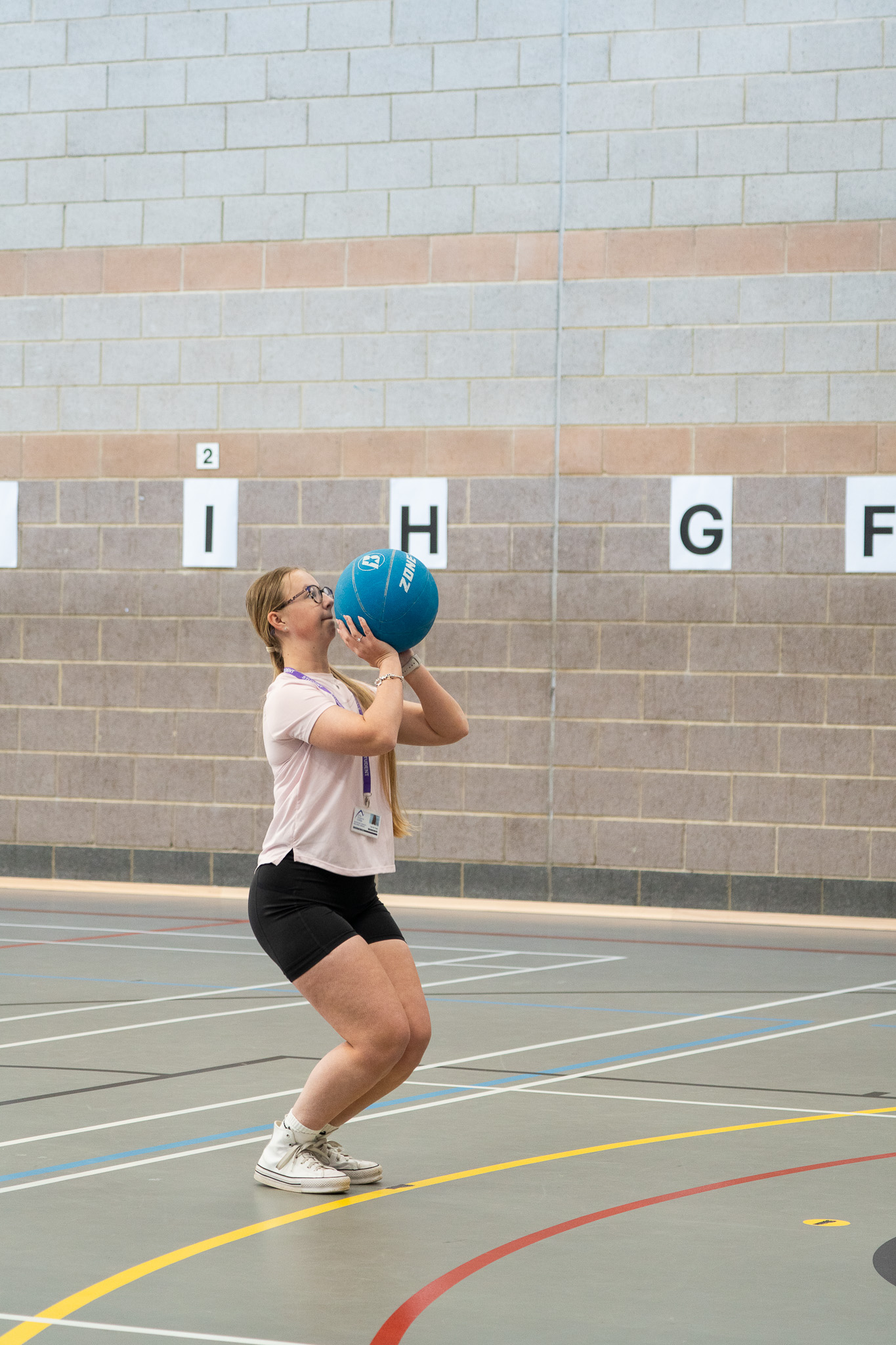 A student shooting a ball in the sports hall