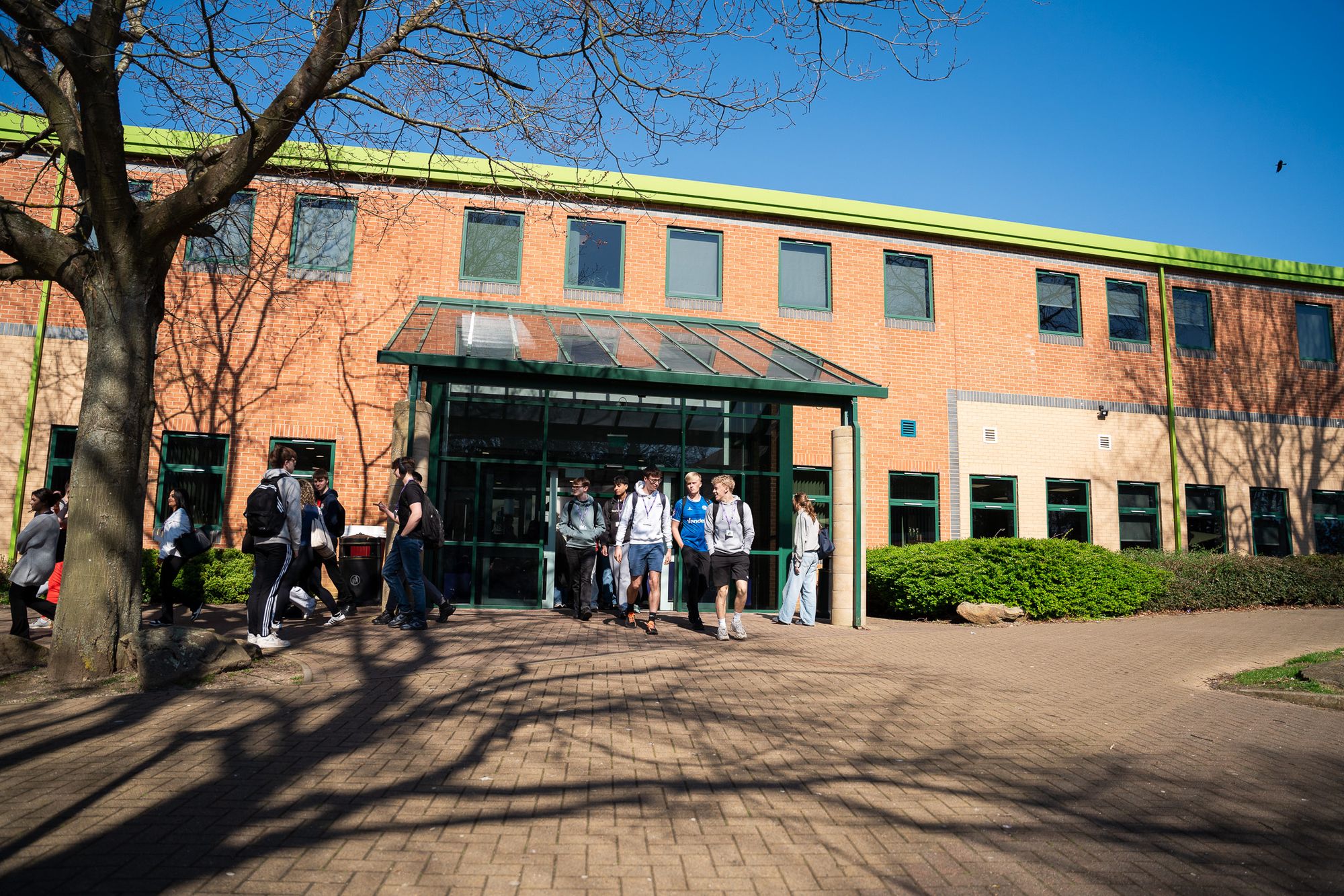 The college building exterior with students near the entrance