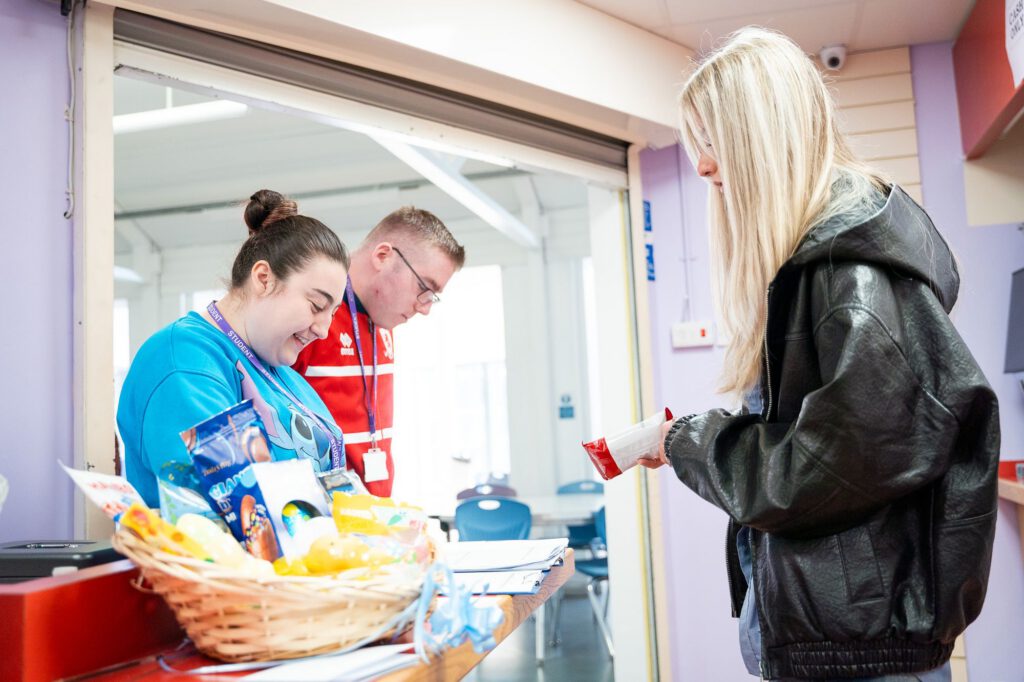 Staff serving a student at the college food hatch