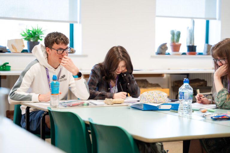 Two students studying a rock sample together