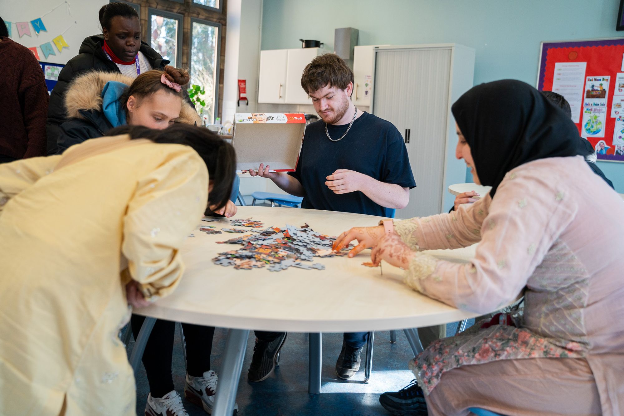 Students building a jigsaw puzzle together in the common room