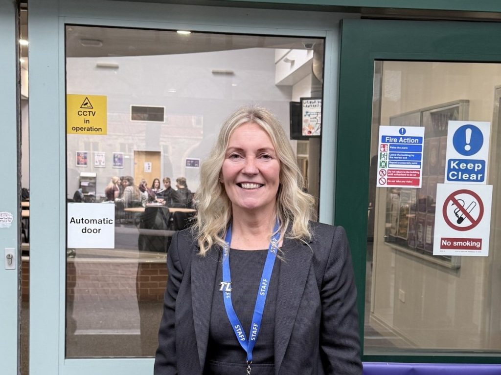 Angela Stevenson, Head of Centre, smiling outside the main entrance of Prior Pursglove College.