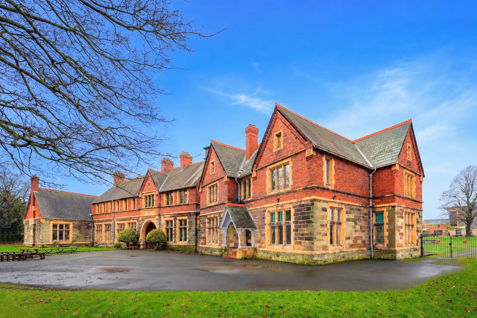 A Victorian red brick and stone college building under a blue sky, Prior Pursglove College.