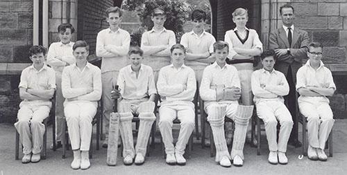 The 1963 cricket team in whites, in two rows in front of the Waterhouse arch, with Mr W. N. Thompson.